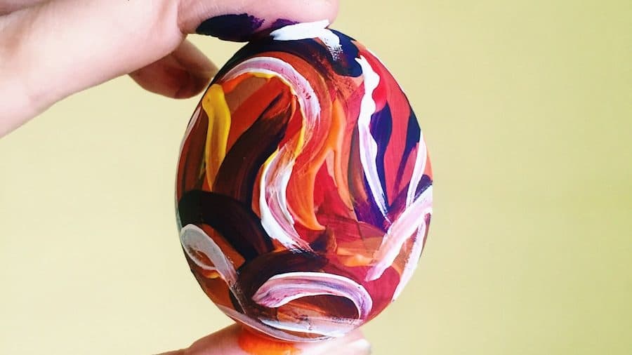 person holding red blue and yellow ball